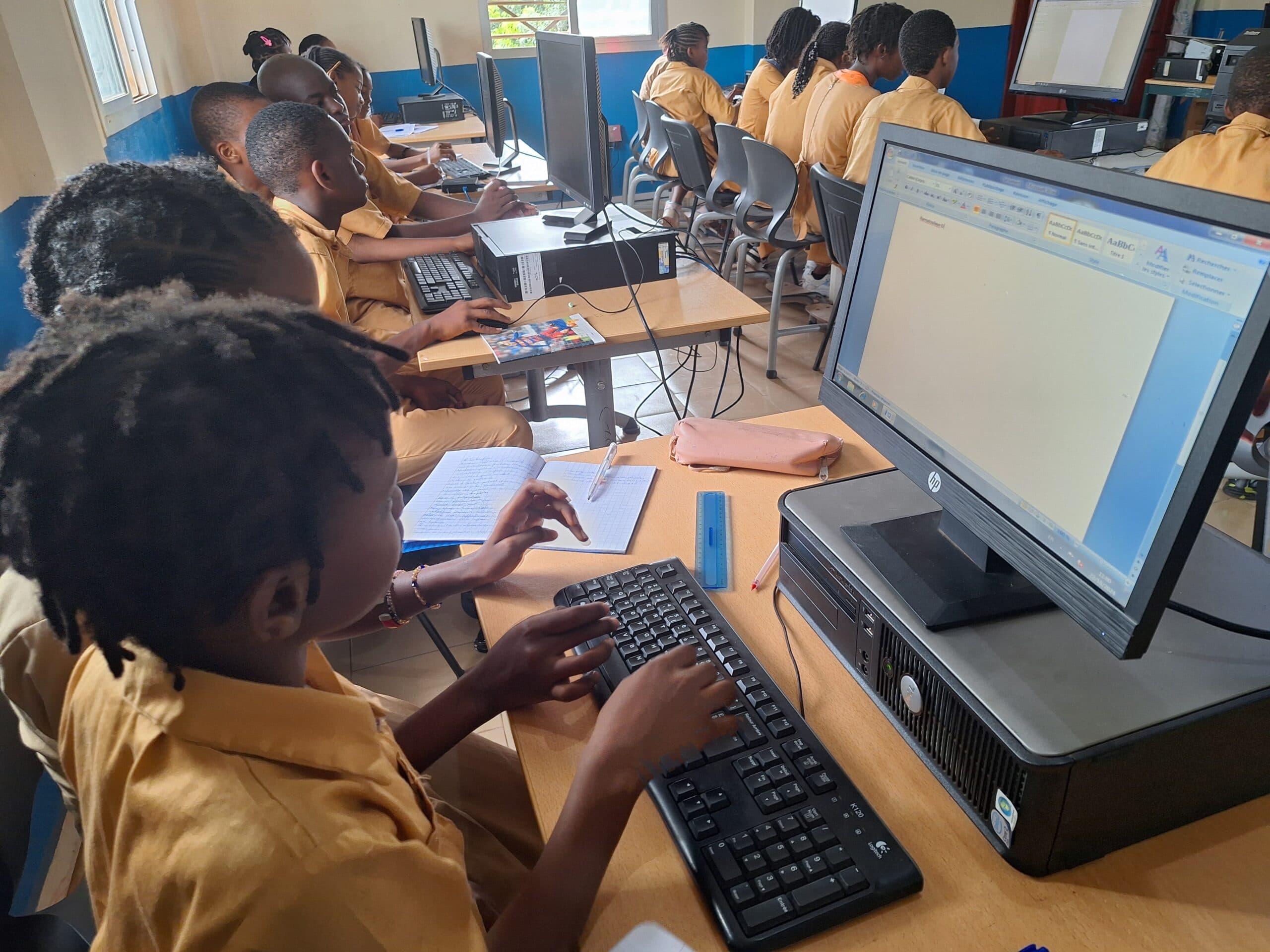 Élève au clavier en salle informatique