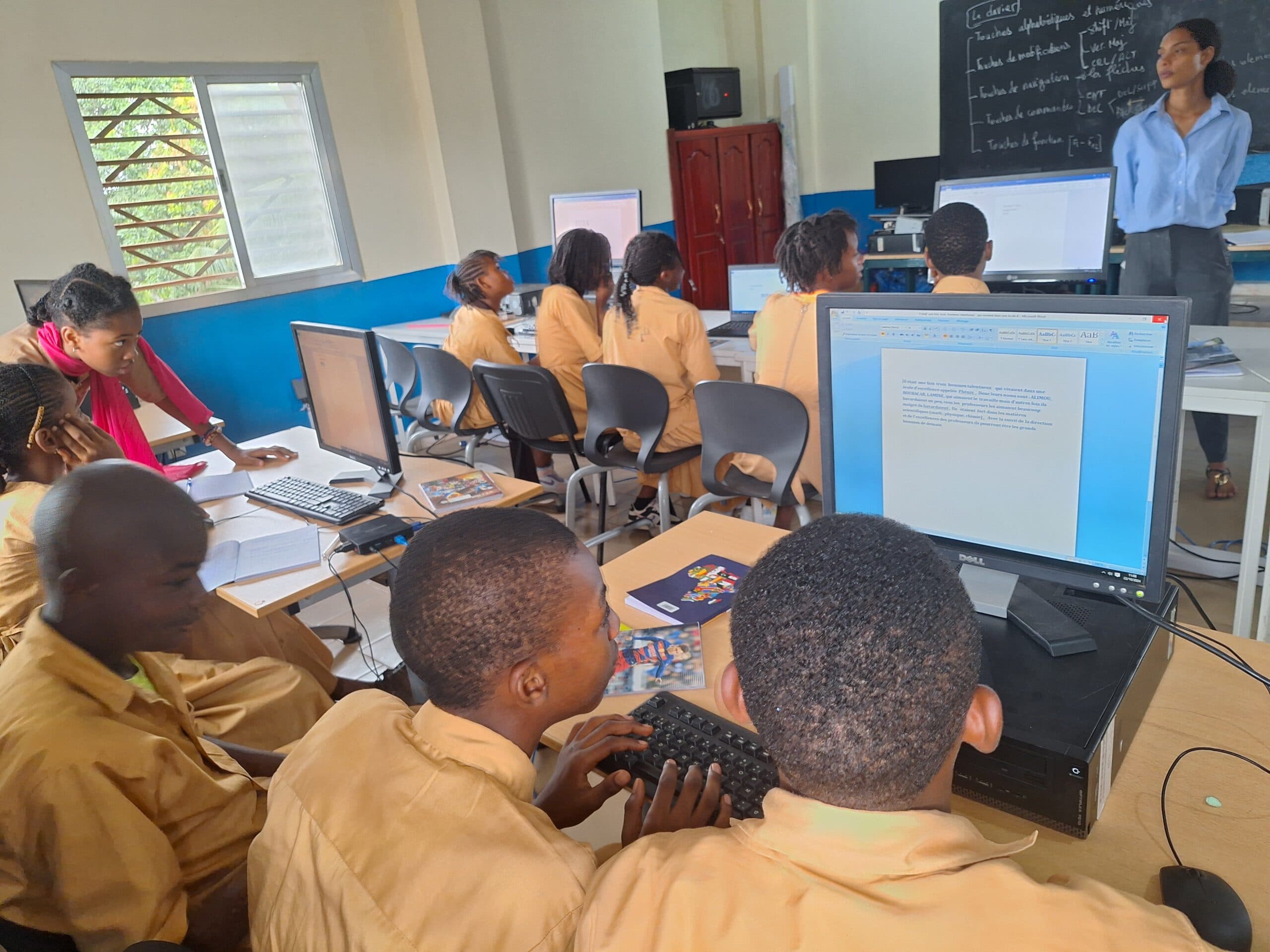 Salle informatique de Phénix International — élèves au travail sur ordinateurs HP